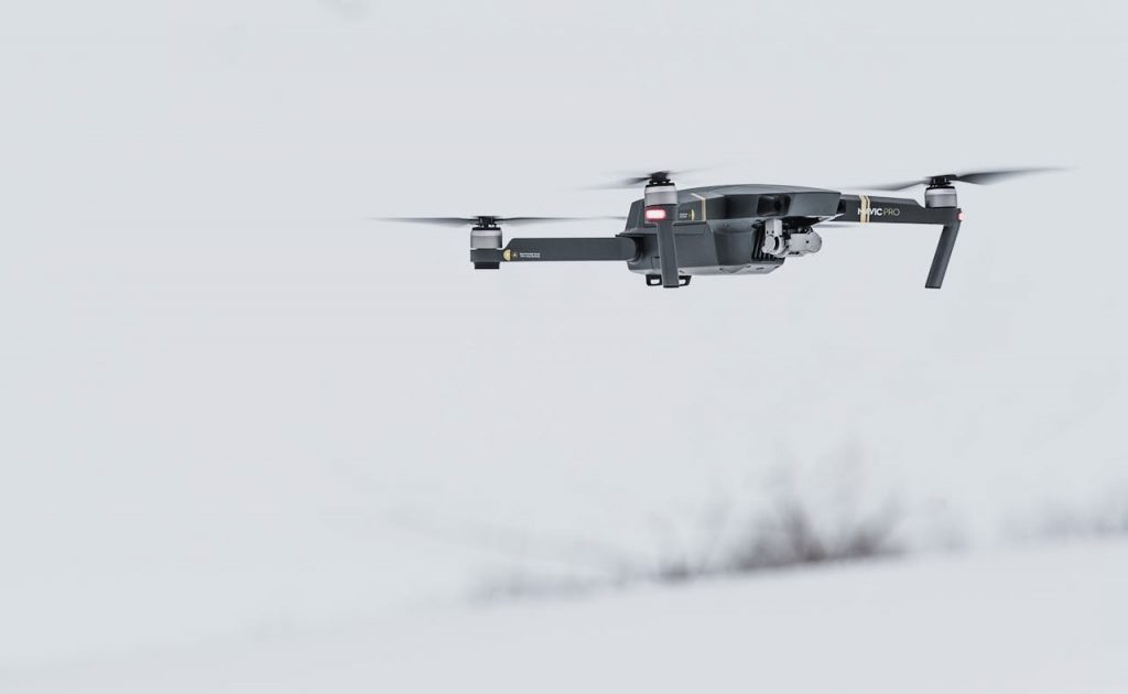 A modern drone flying over a serene, snow-covered setting, showcasing advanced technology.